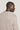 Sand-colored crewneck sweatshirt with ribbed texture, shown from back on model in profile view.