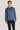 Man wearing blue crewneck sweatshirt with ribbed cuffs and hem, paired with dark navy pants.