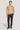 Sand-colored crewneck sweater with cable knit pattern worn with dark trousers and brown leather shoes.
