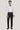 White tuxedo shirt with pleated front and black bow tie, worn with black trousers.