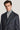 Dark blue double-breasted suit jacket with brown windowpane pattern worn over gray turtleneck.