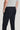 Dark navy stretch trousers with flat front, side pockets, and button closure shown from back detail view.