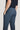 Blue-grey plain front trousers with flat front closure and button detail on wearer.