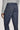 Navy denim tailored trousers with side fasteners and button closure, shown from waist to hem on model wearing gray sweater.