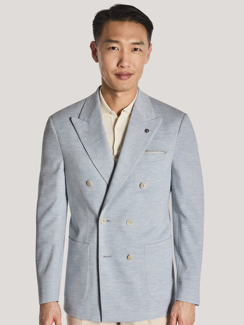 Sky blue melange double-breasted blazer with gold buttons and notch lapels, worn over cream shirt with cream trousers.