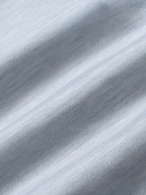 Sky blue melange fabric with textured weave and diagonal folds showing blazer material detail.