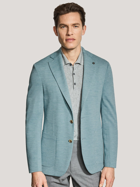 Man wearing teal melange blazer with notched lapels and button closure over gray shirt.