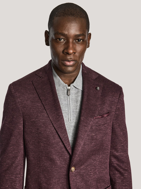 Burgundy melange blazer with notch lapels and button front, worn over gray zip-up shirt.