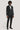 Man wearing dark textured dinner jacket with bow tie, white dress shirt, black trousers, and black shoes.